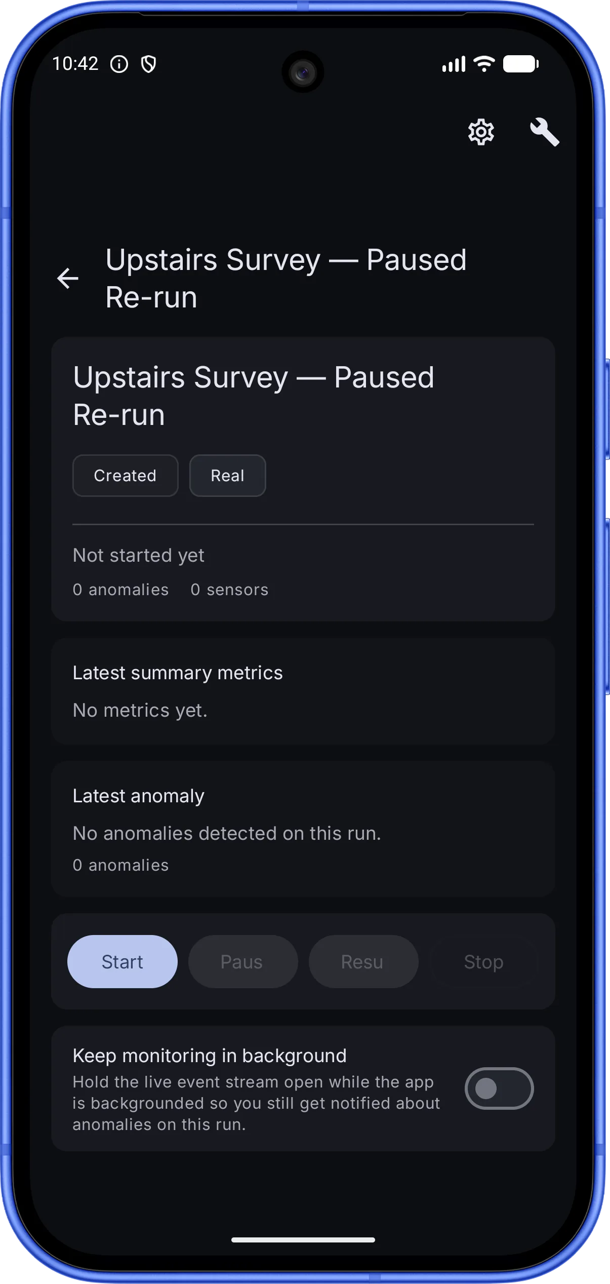 TameChaos Field on an Android phone showing a single run, “Upstairs Survey — Paused Re-run”, on an associated Edge server: status and type chips (Created, Real), latest-summary-metrics and latest-anomaly panels, Edge-gated run-control buttons (Start, Pause, Resume, Stop), and a “Keep monitoring in background” toggle that holds the live event stream open so anomalies still surface when the app is backgrounded.